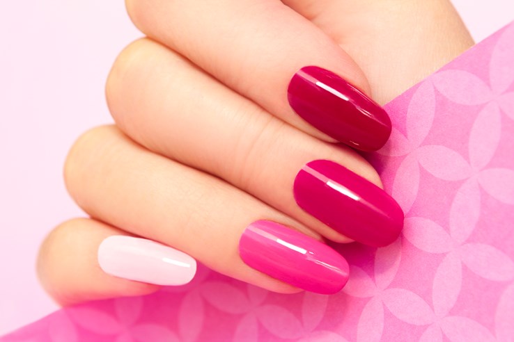 Multicolored manicure with different shades of pink nail Polish on women's hand